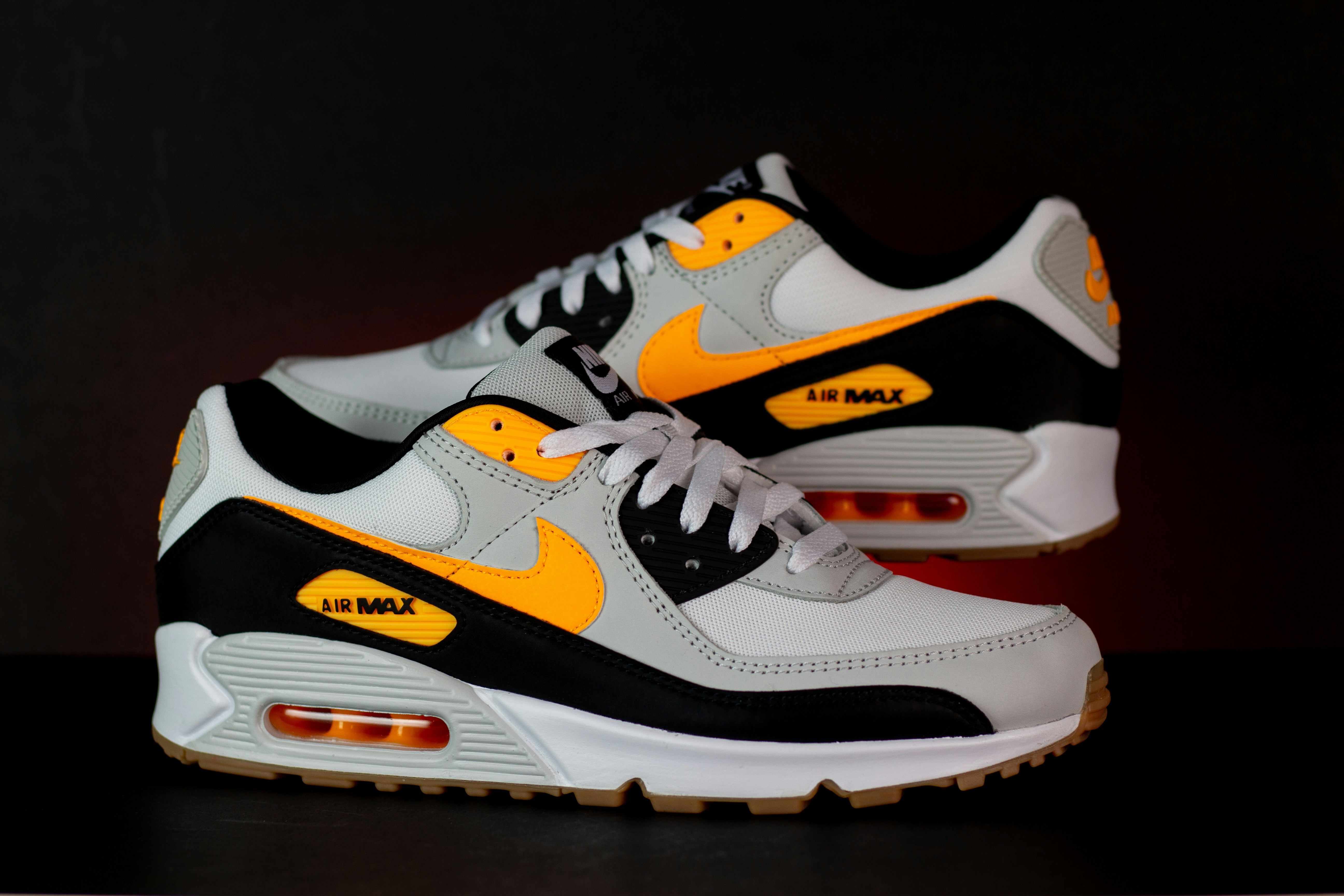 a pair of white and yellow sneakers on a table