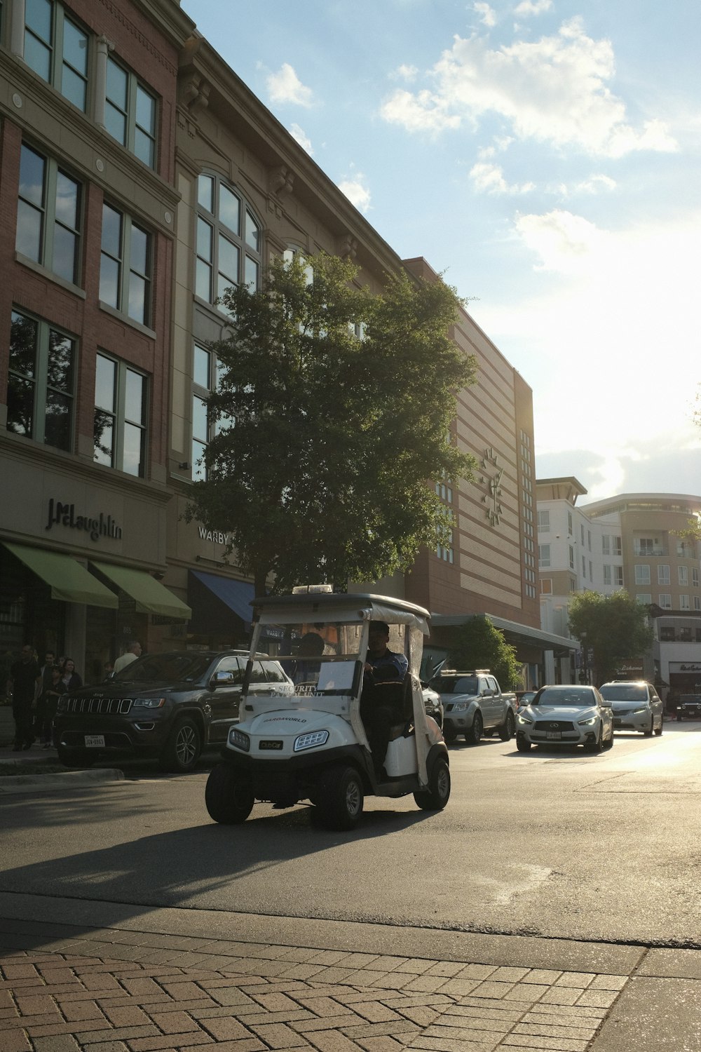 Un carrito de golf conduciendo por una calle de la ciudad