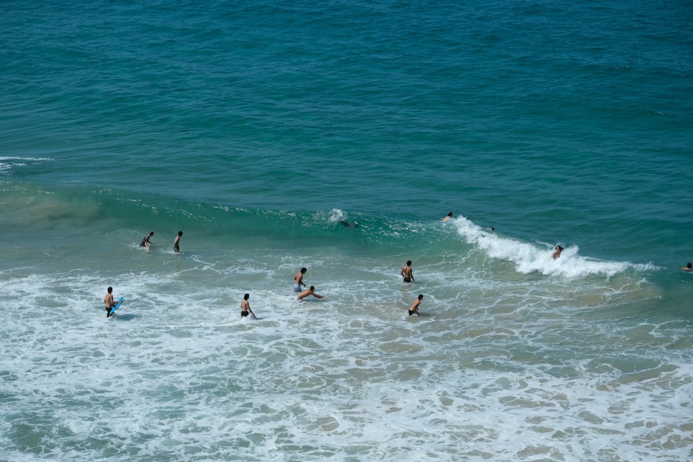 a group of people riding surfboards on top of a wave