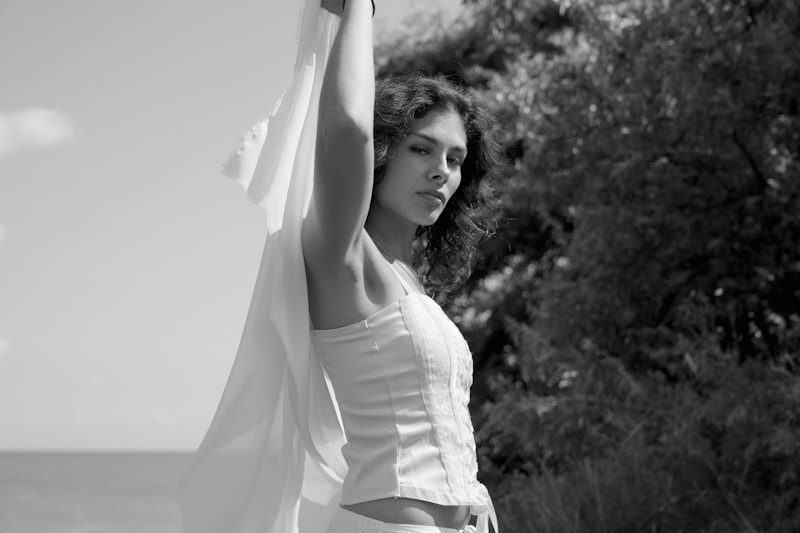 Joyful woman raising arms in white
