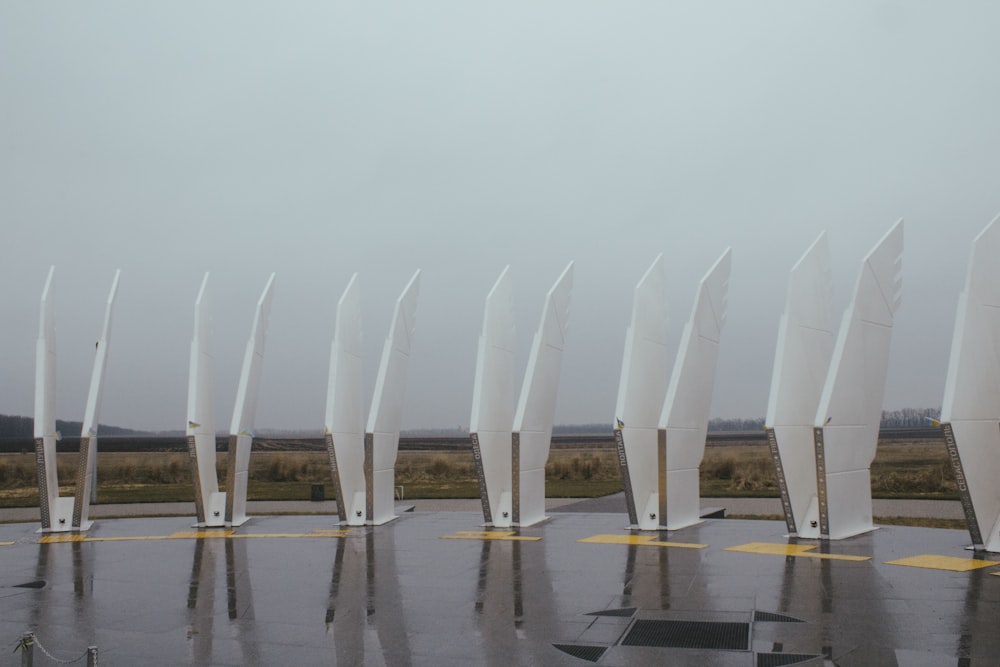a row of white flags sitting on top of a tarmac