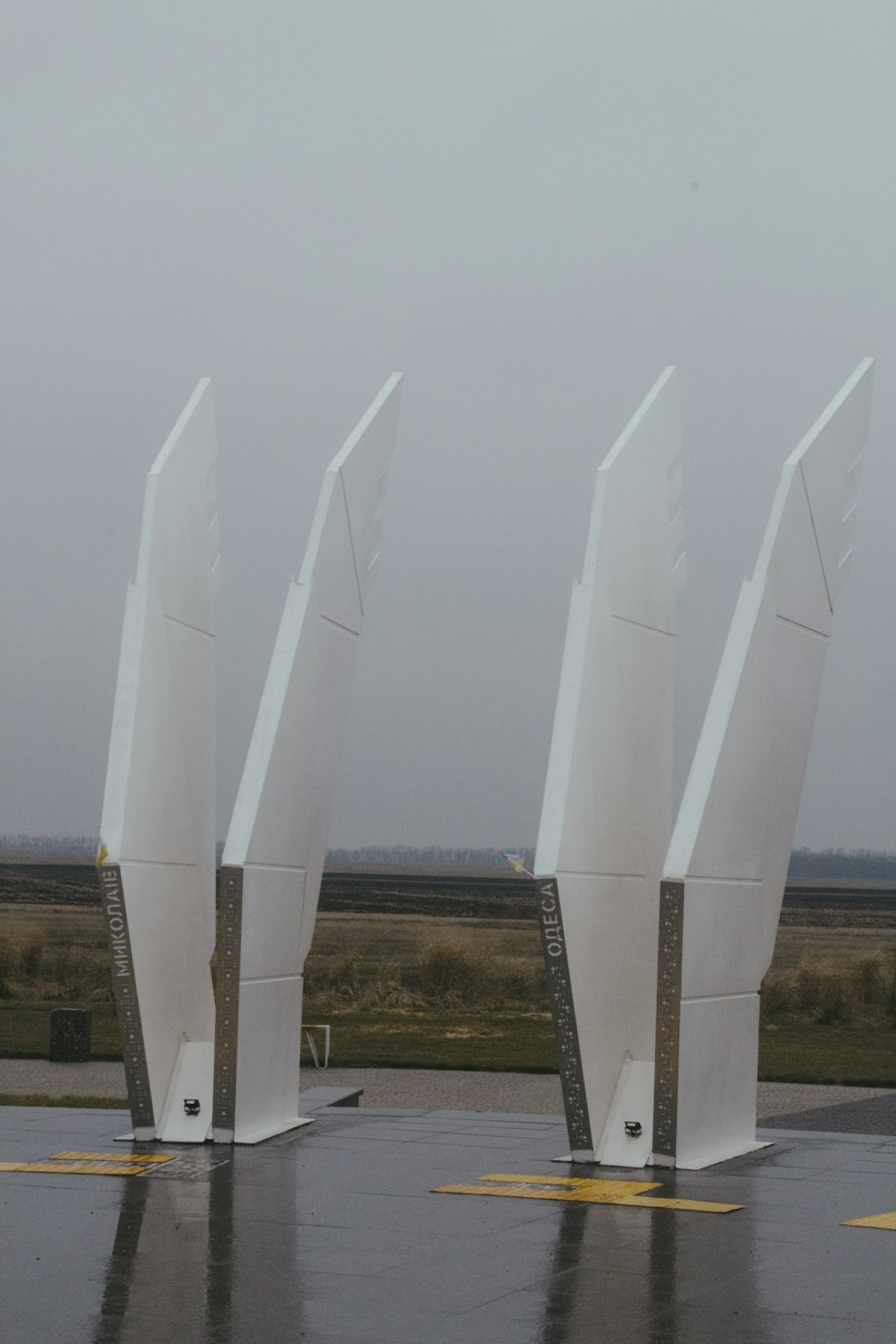 a row of white sculptures sitting on top of an airport tarmac