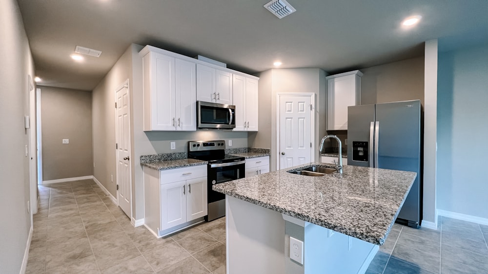 a kitchen with white cabinets and granite counter tops