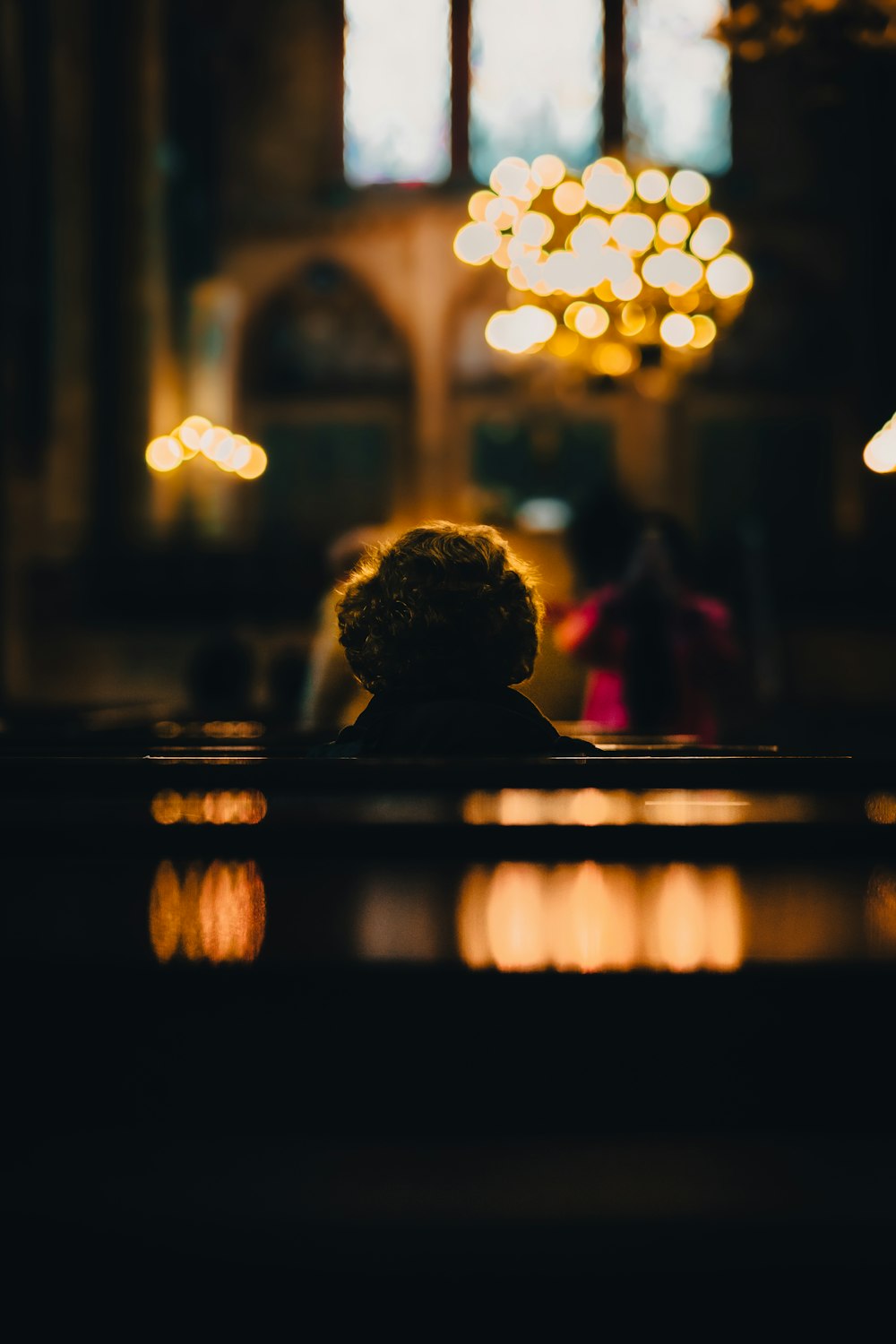 Ein Teddybär sitzt auf einer Bank in einer Kirche