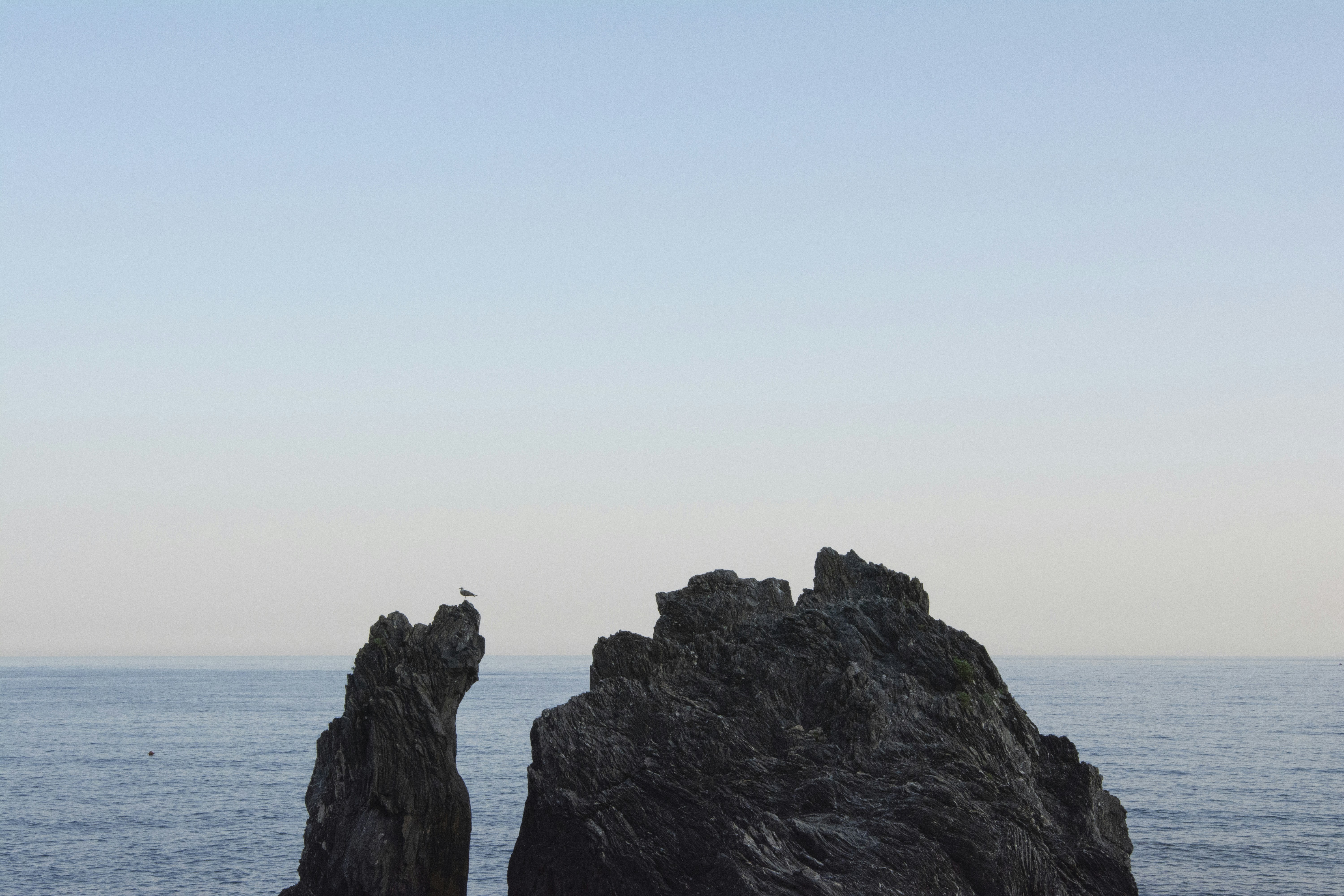 a couple of large rocks sitting in the middle of the ocean