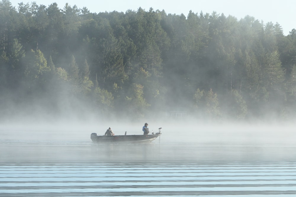 two people in a boat on a misty lake