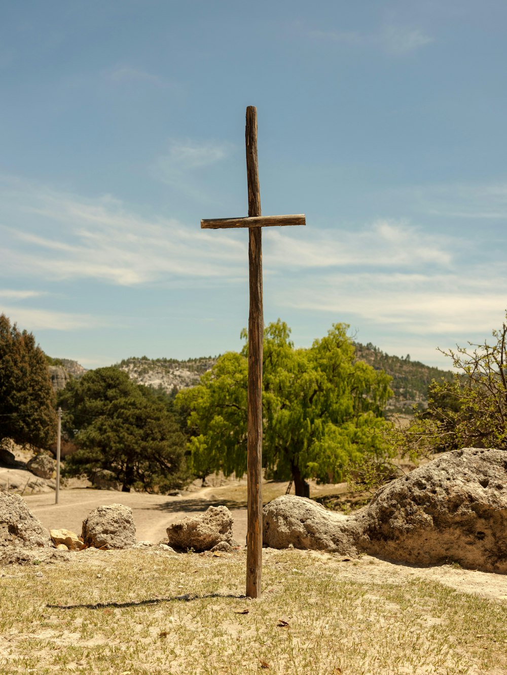 a wooden cross sitting in the middle of a field