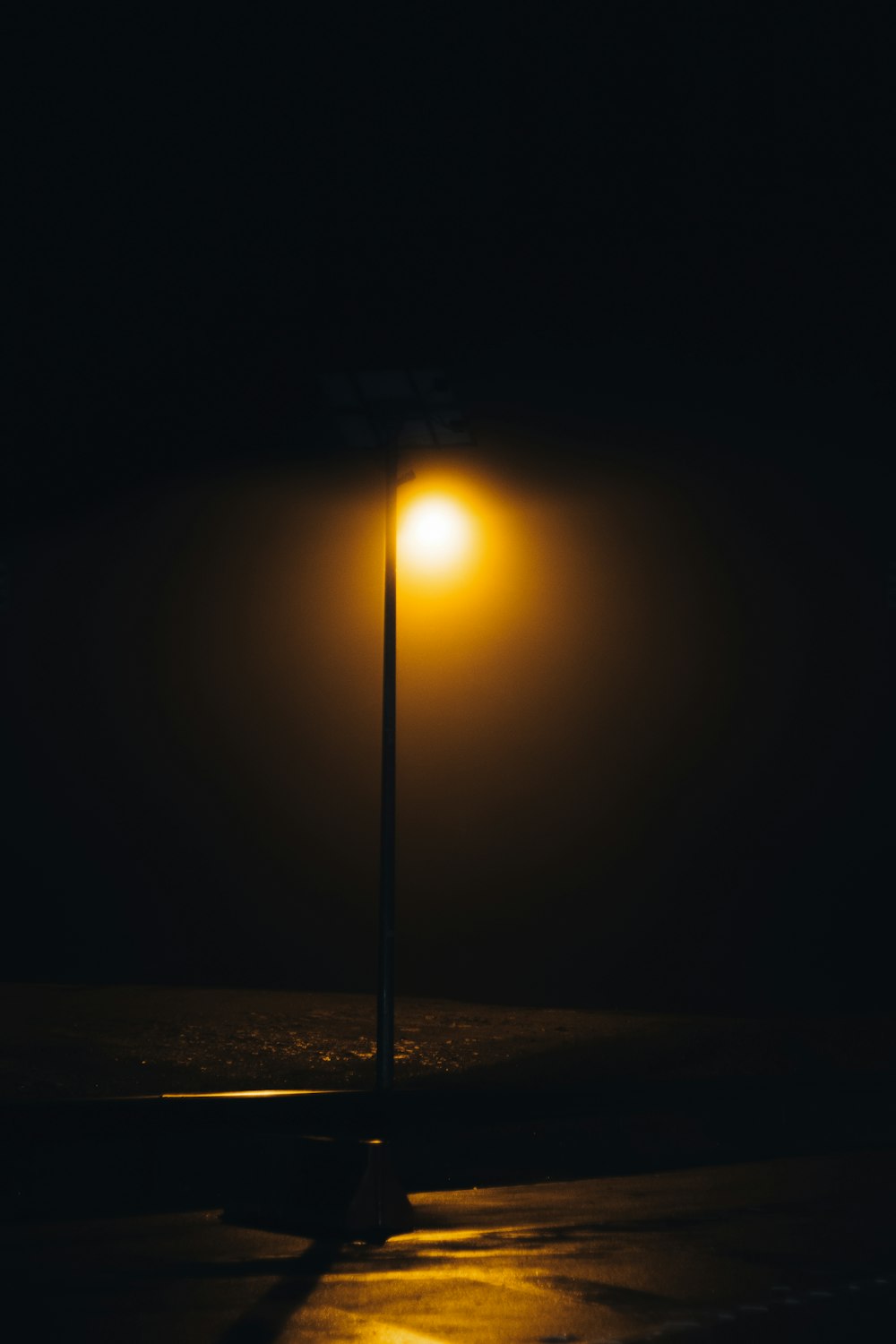 eine Straßenlaterne auf einer dunklen Straße in der Nacht
