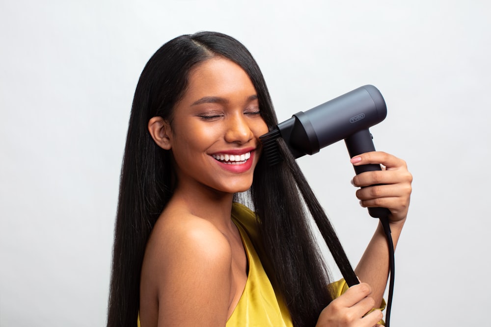 a woman blow drying her hair with a hair dryer