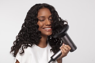 a woman using a hair dryer to dry her hair