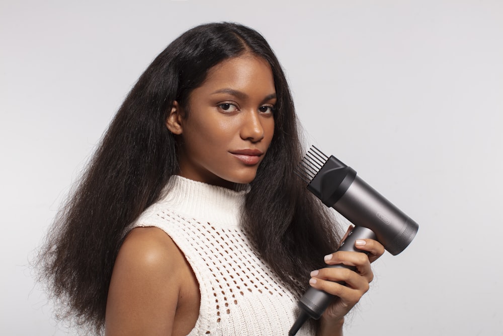 a woman holding a hair dryer in her hand