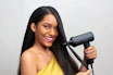 a woman holding a hair dryer and smiling