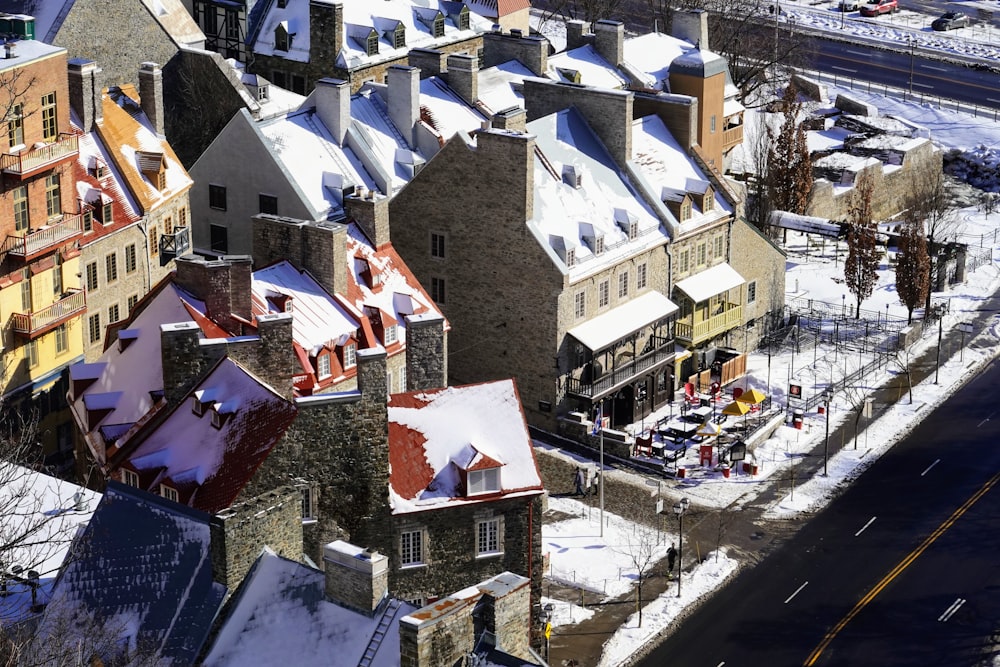 an aerial view of a city with snow on the roofs