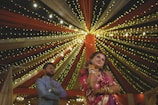 a man and a woman standing in front of a decorated ceiling