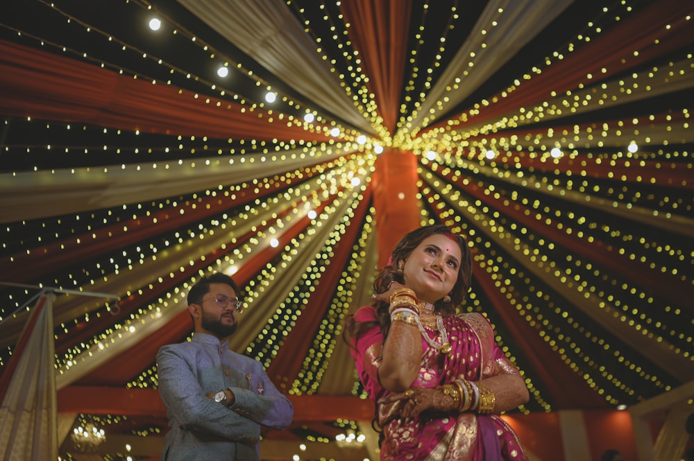 a man and a woman standing in front of a decorated ceiling