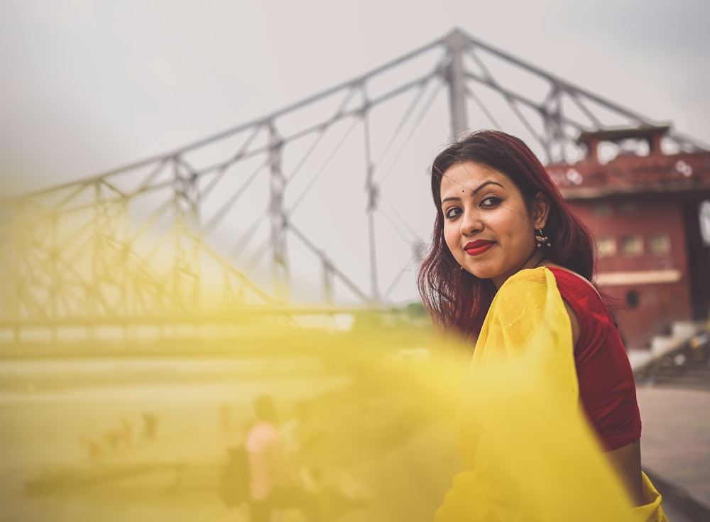 a woman standing in front of a bridge