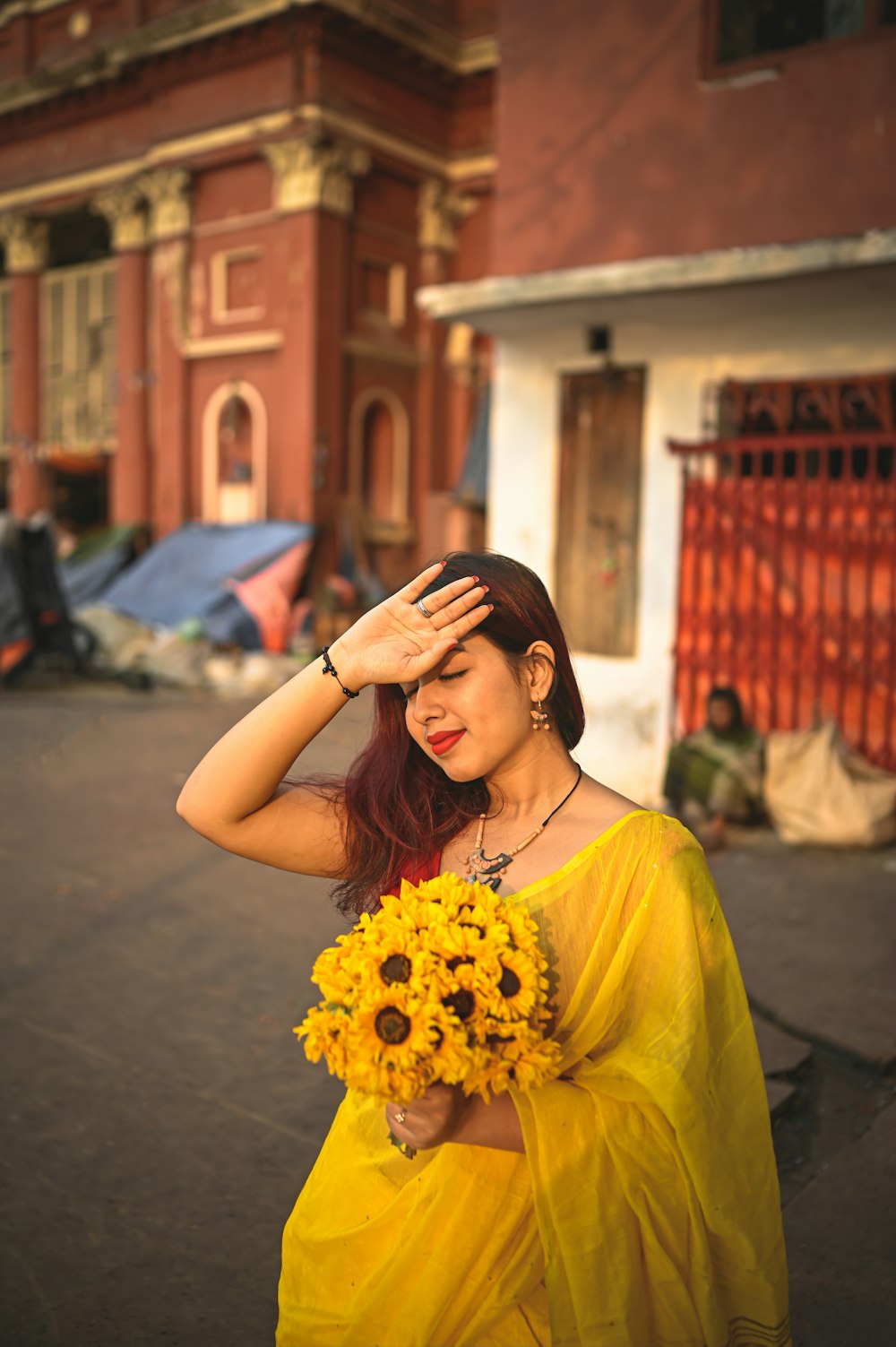 a woman in a yellow dress holding a bouquet of sunflowers