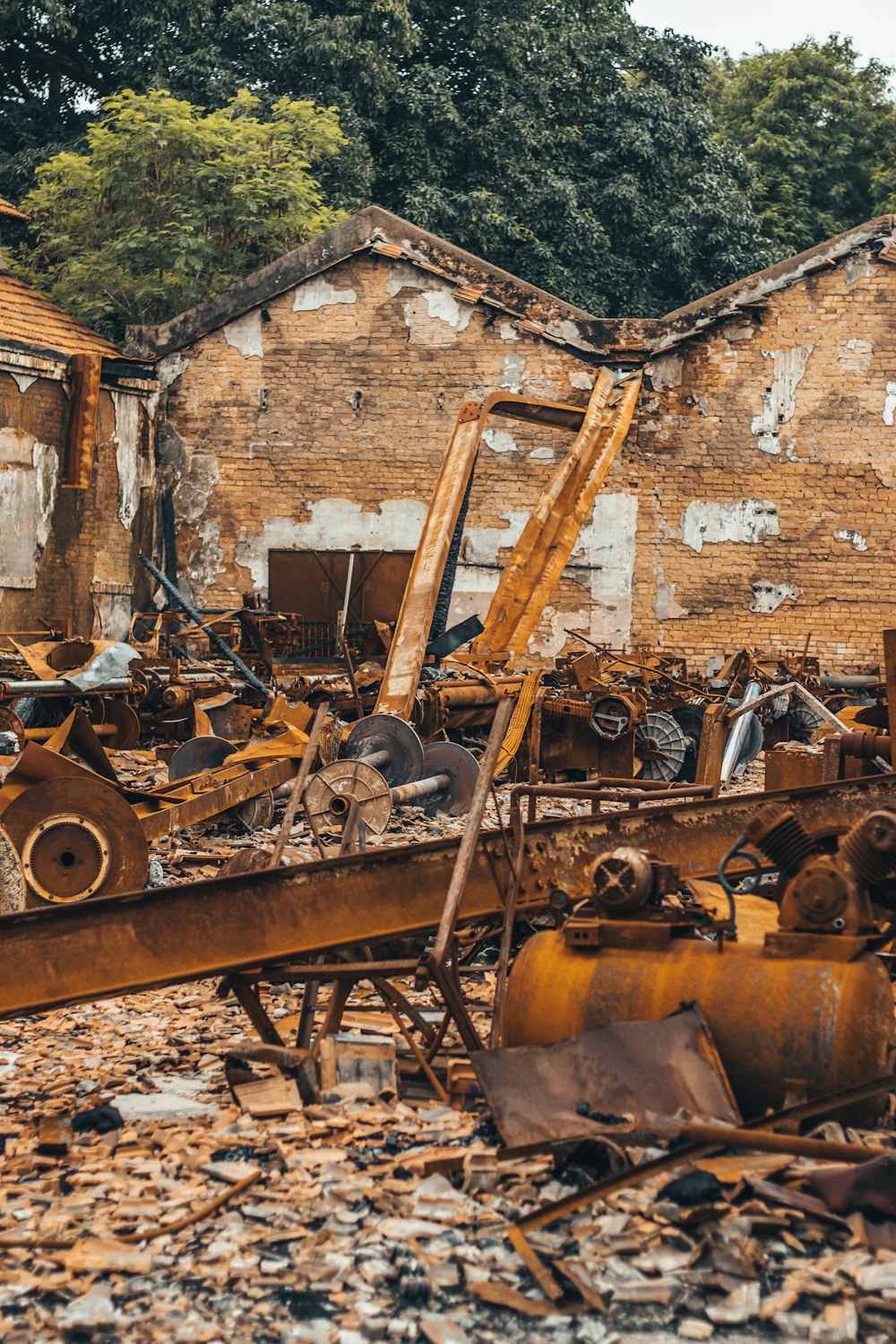 a bunch of rusted out buildings with trees in the background