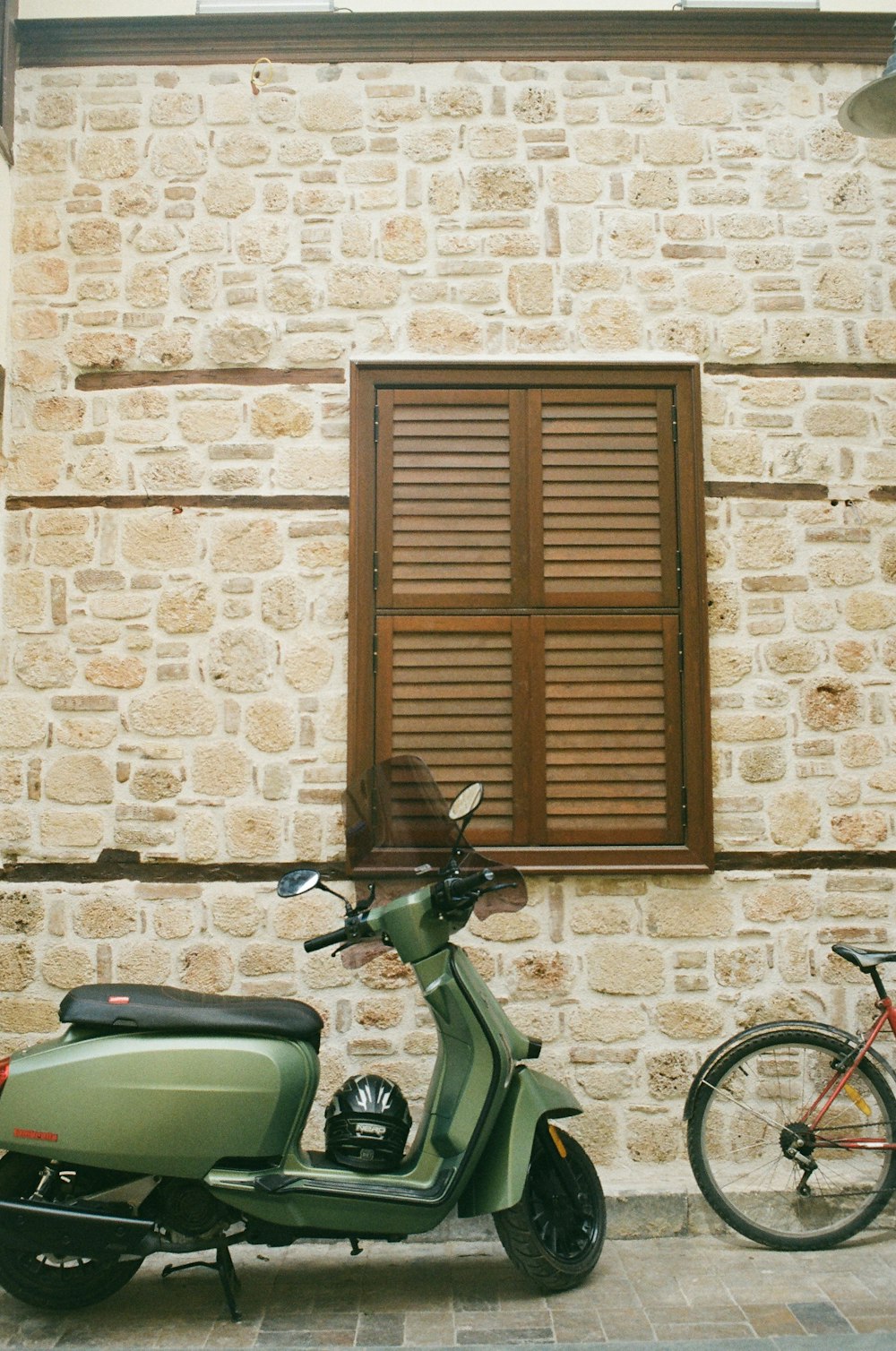 a green scooter parked next to a bicycle