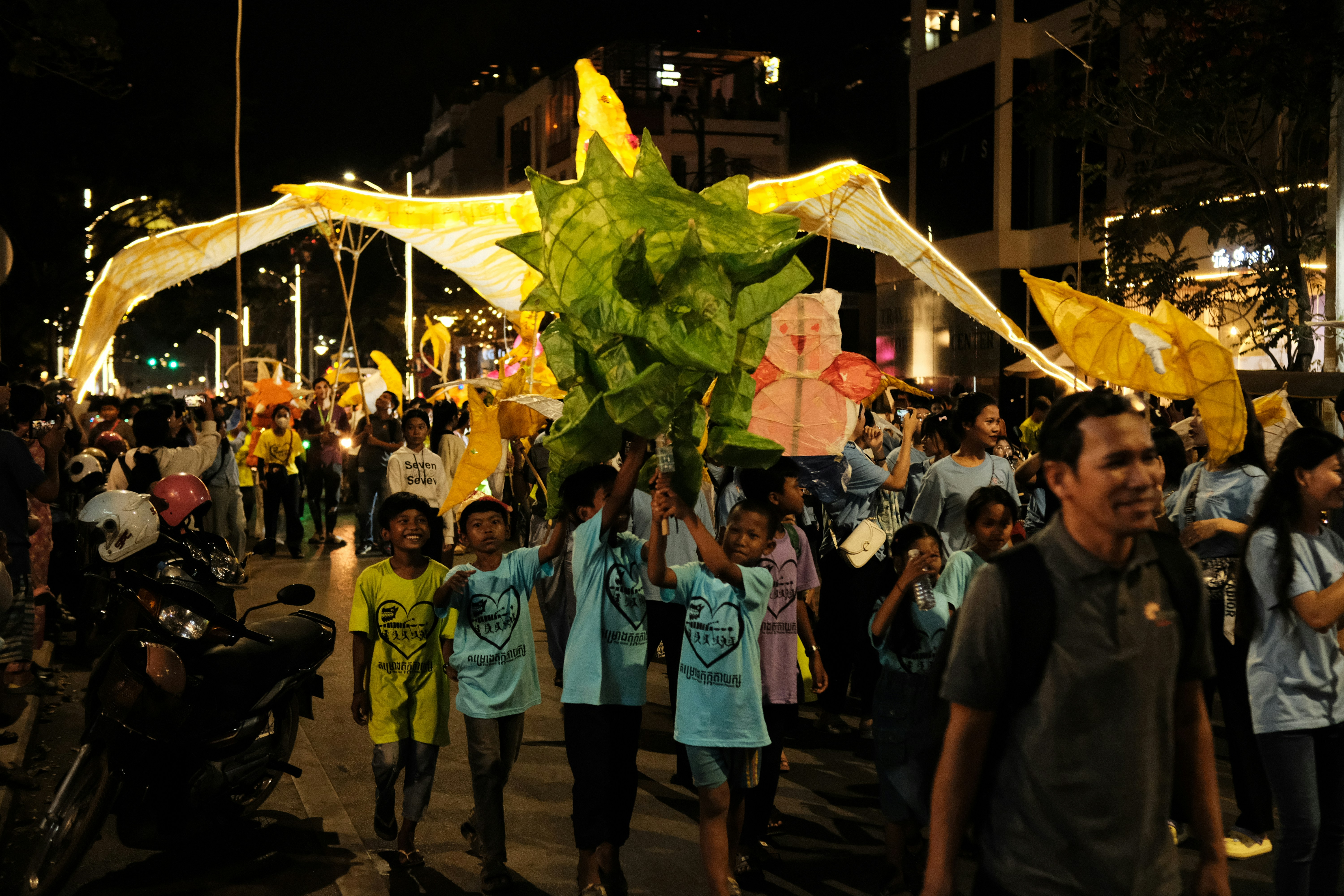 a crowd of people walking down a street at night