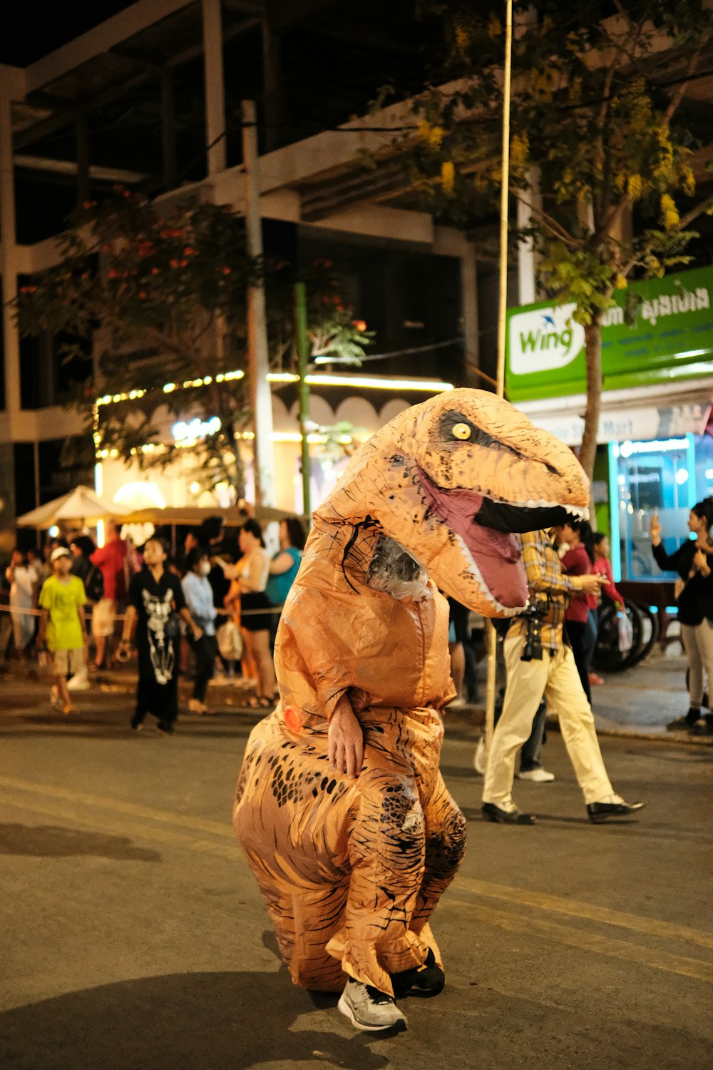 a man in a dinosaur costume walking down a street