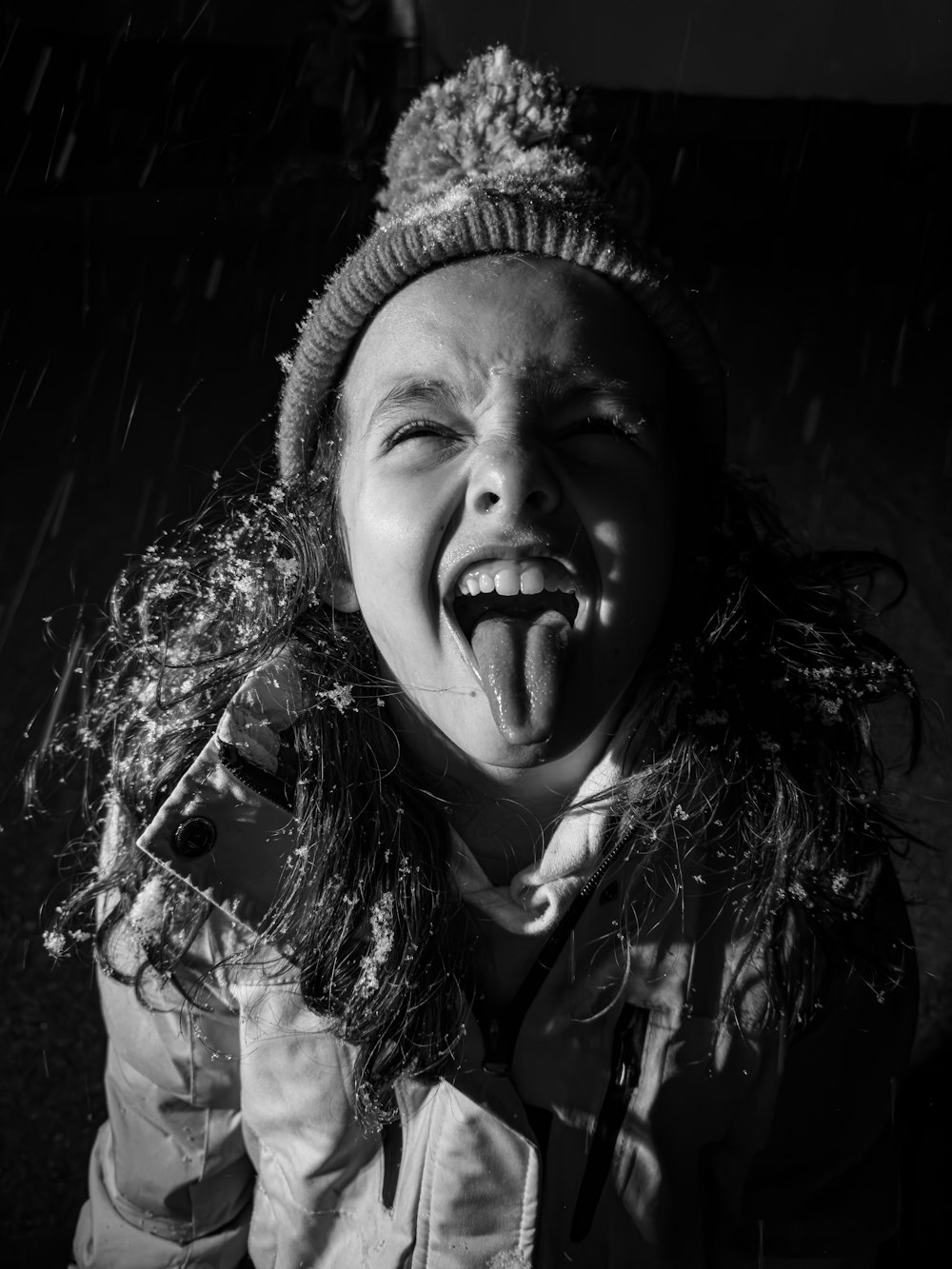 a young girl making a funny face in the rain