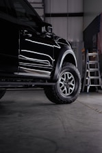 a truck parked inside of a garage next to a ladder