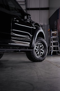 a truck parked inside of a garage next to a ladder