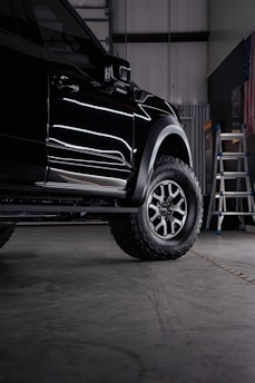 a truck parked inside of a garage next to a ladder