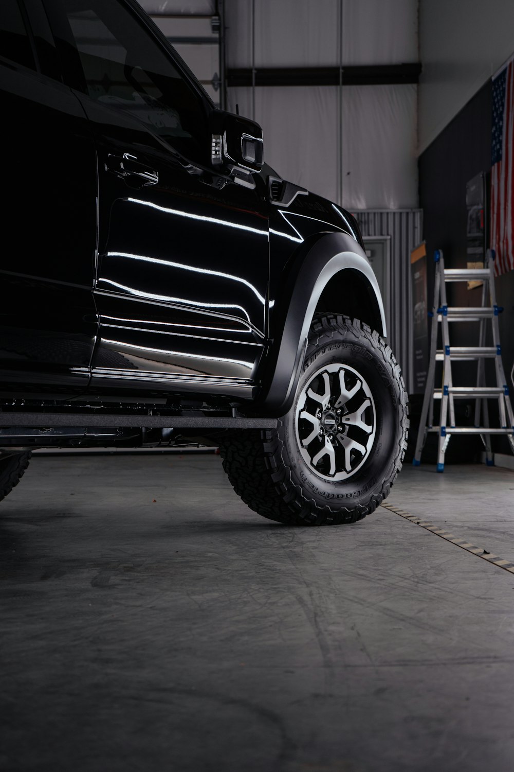 a truck parked inside of a garage next to a ladder