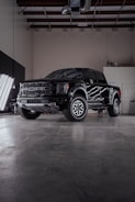 a black truck parked inside of a garage