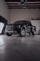a black truck parked inside of a garage