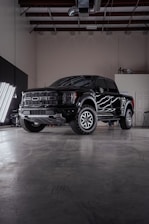 a black truck parked inside of a garage