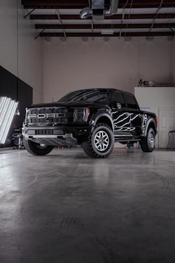 a black truck parked inside of a garage