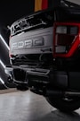 the rear end of a black truck parked in a garage