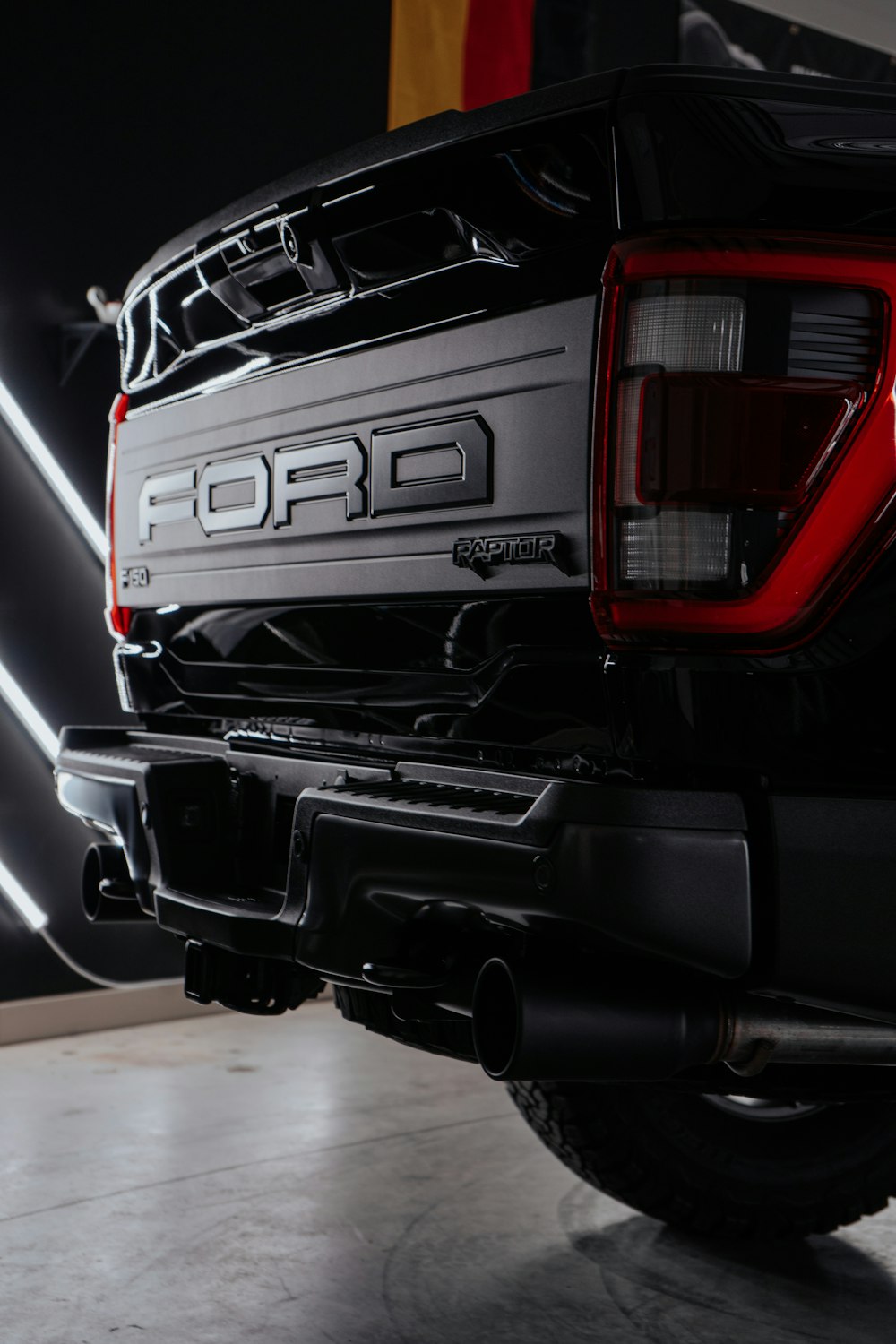 the rear end of a black truck parked in a garage