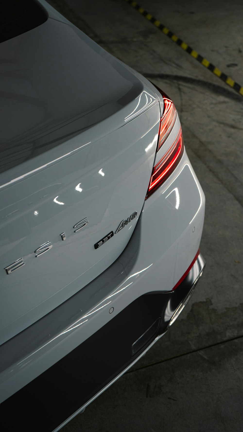 the back end of a white car parked in a garage