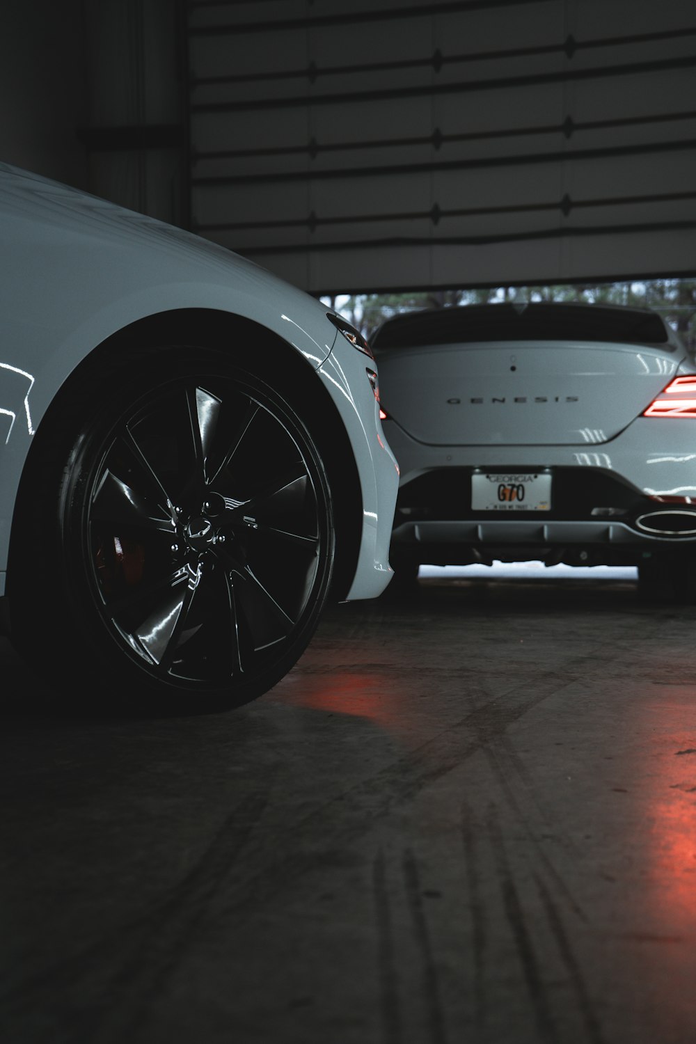 two white sports cars parked in a garage