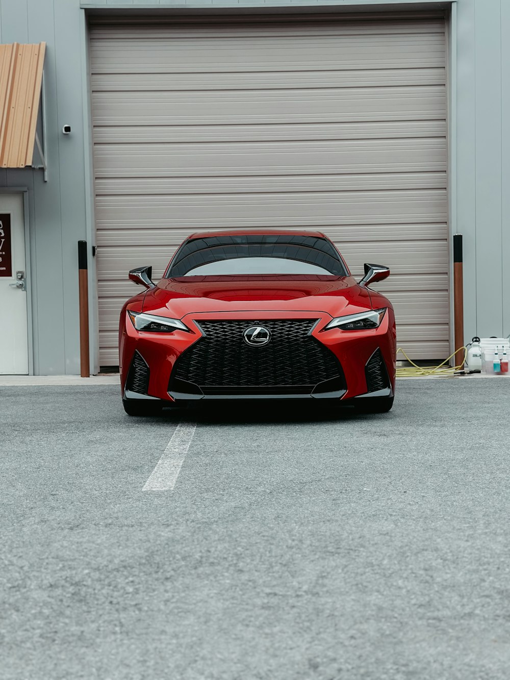 a red sports car parked in front of a garage