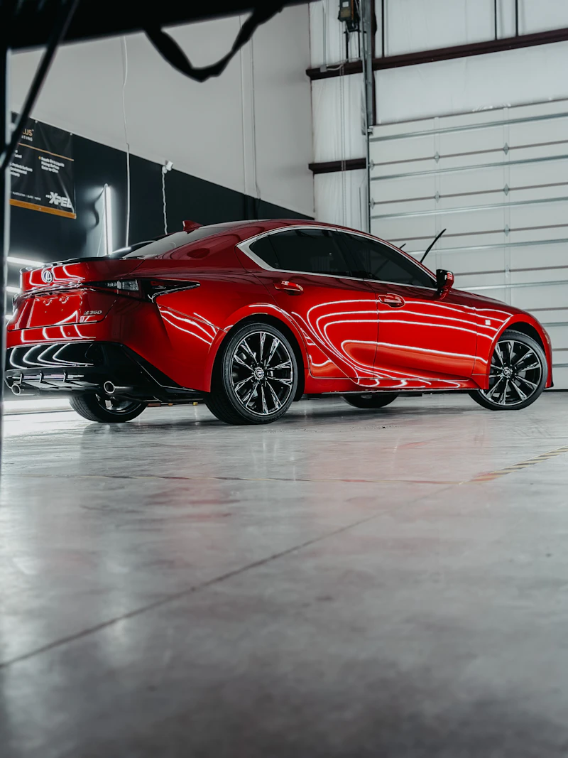 Freshly detailed red sports car parked in a garage