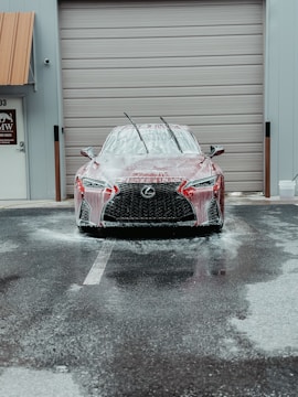 a car covered in snow parked in front of a garage