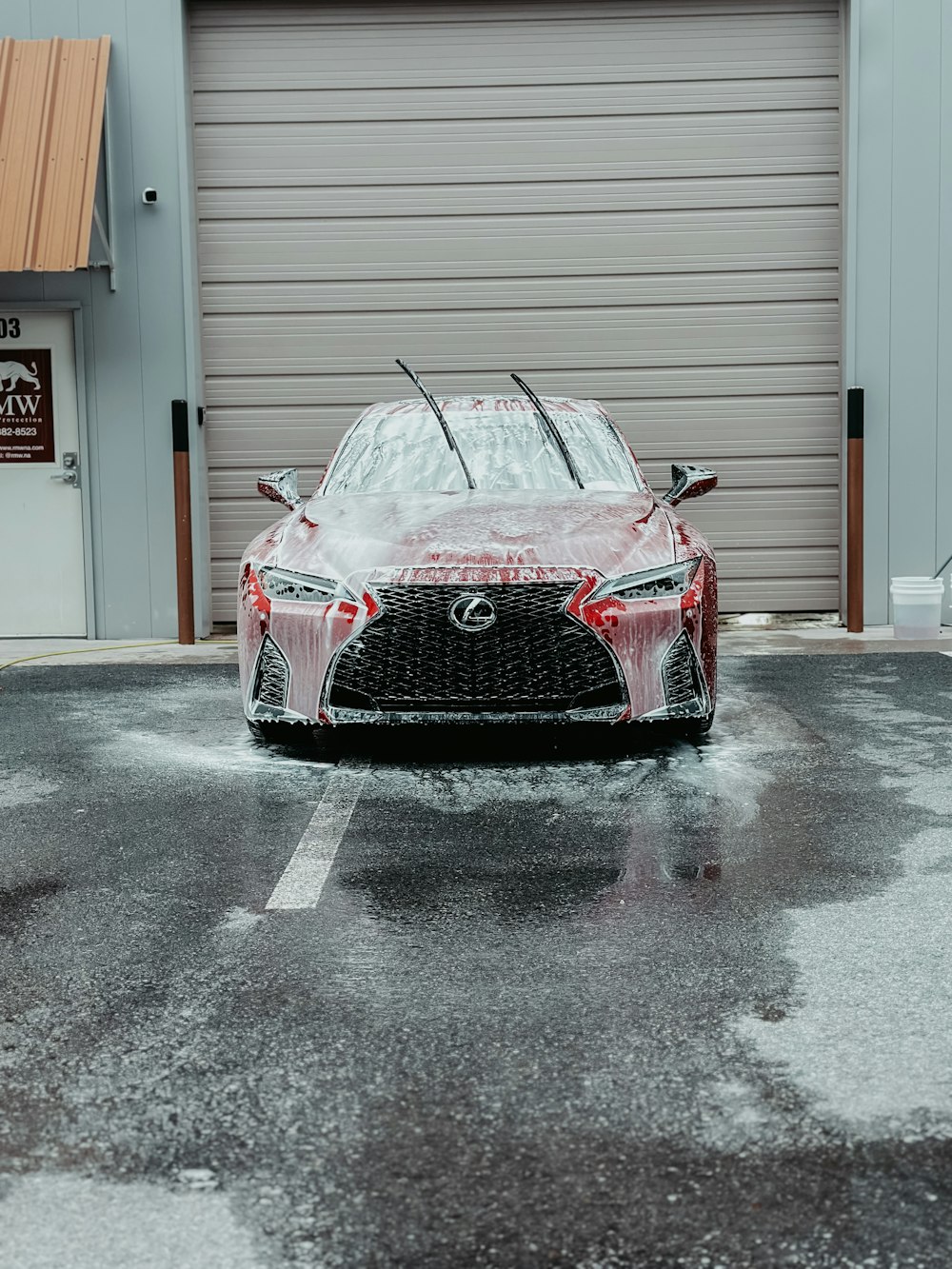 a car covered in snow parked in front of a garage