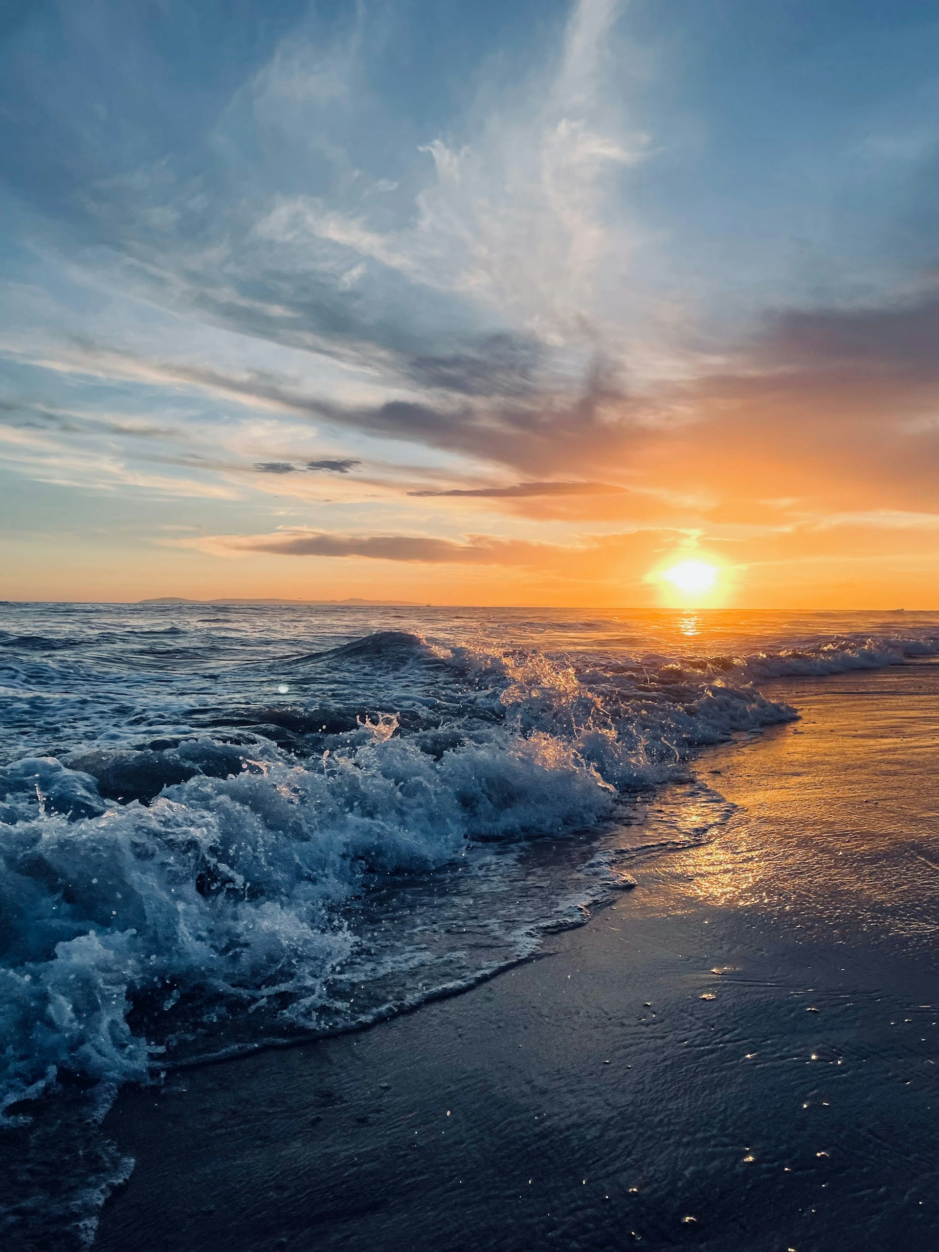 the sun is setting over the ocean waves