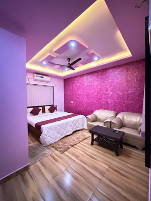 a room with a bed, couch and a ceiling fan