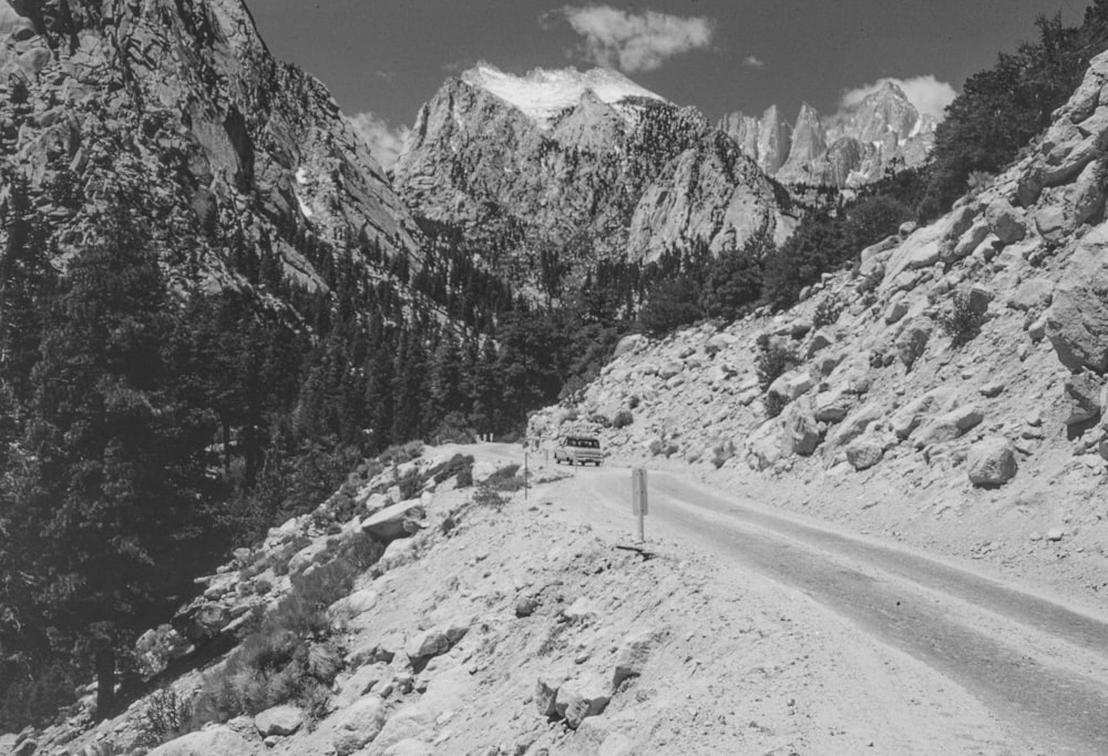 a black and white photo of a mountain road
