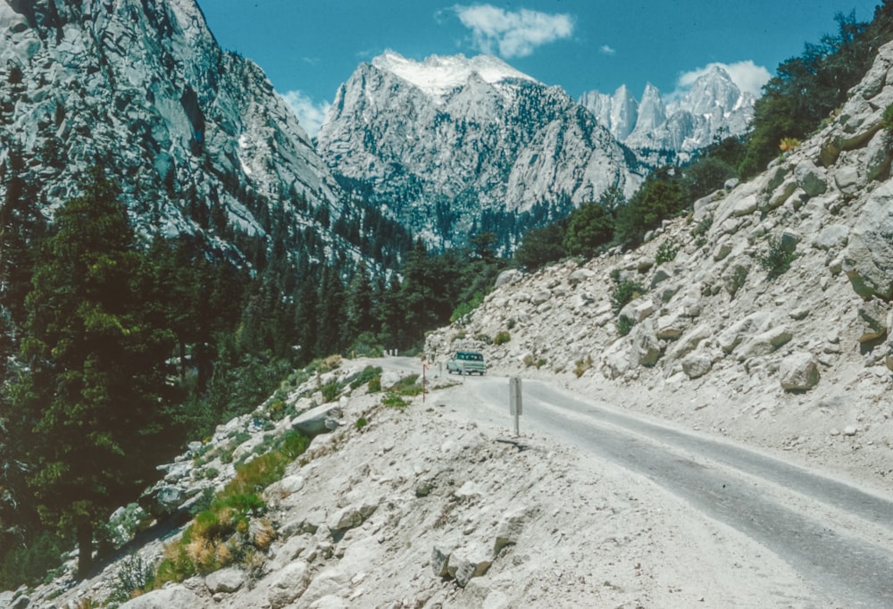 a person walking down a road in the mountains