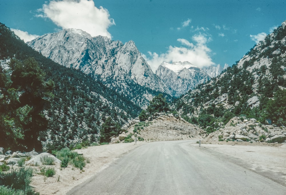 a dirt road with mountains in the background