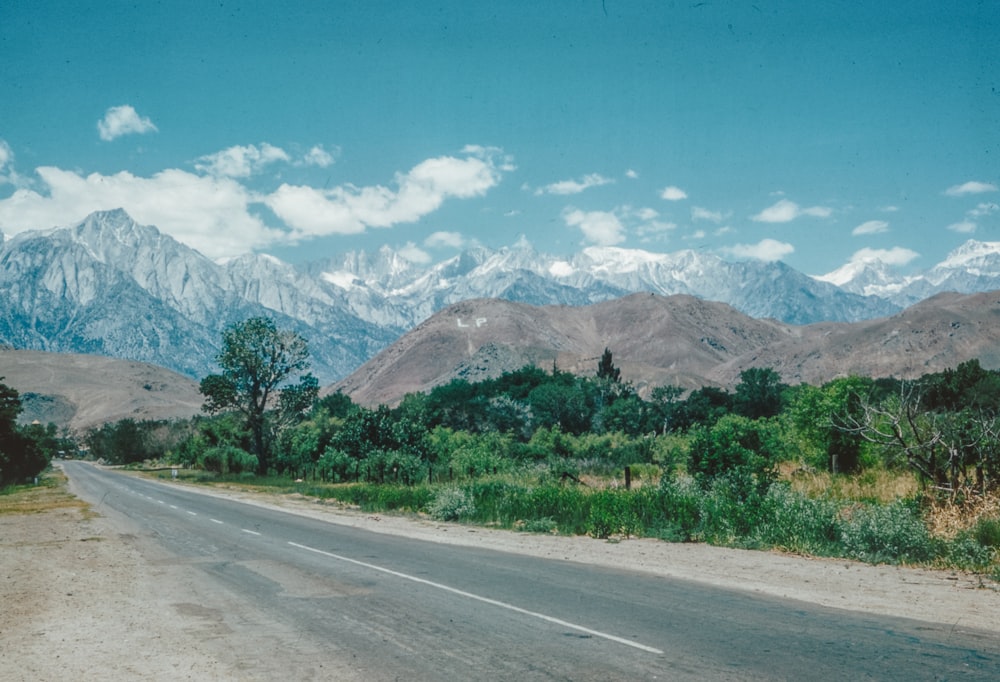 an empty road with mountains in the background