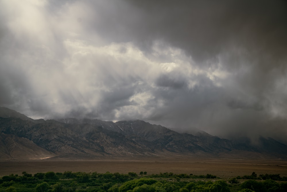 a large mountain range under a cloudy sky