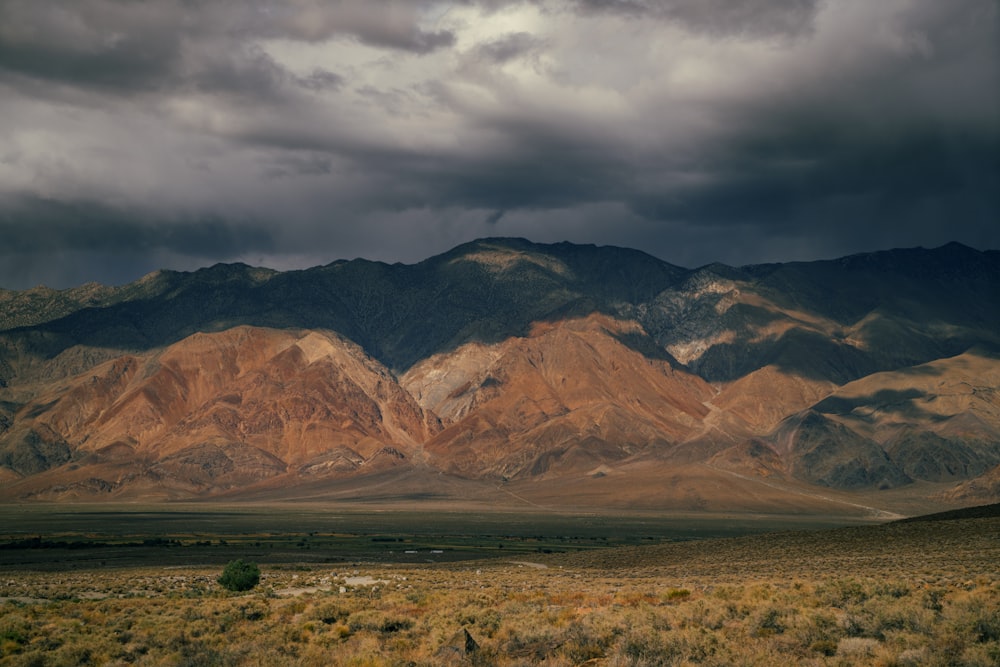 a mountain range with a cloudy sky in the background